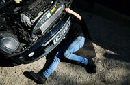 Person under car repairs Getty Images Person under car repairs Getty Images