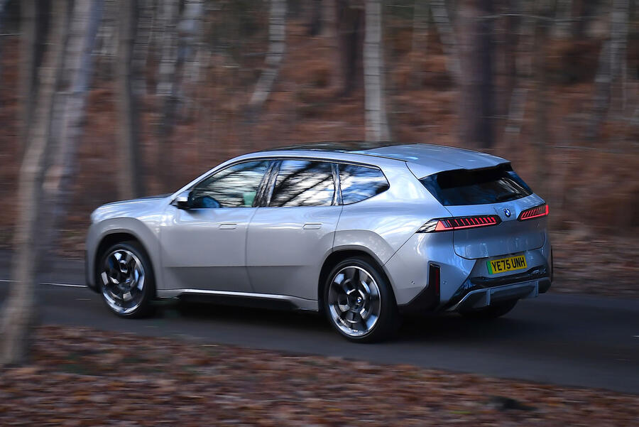 BMW iX3 driving through a forest – rear