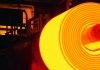 hot coil in a furnace being made. Illuminated steel coil in the dark