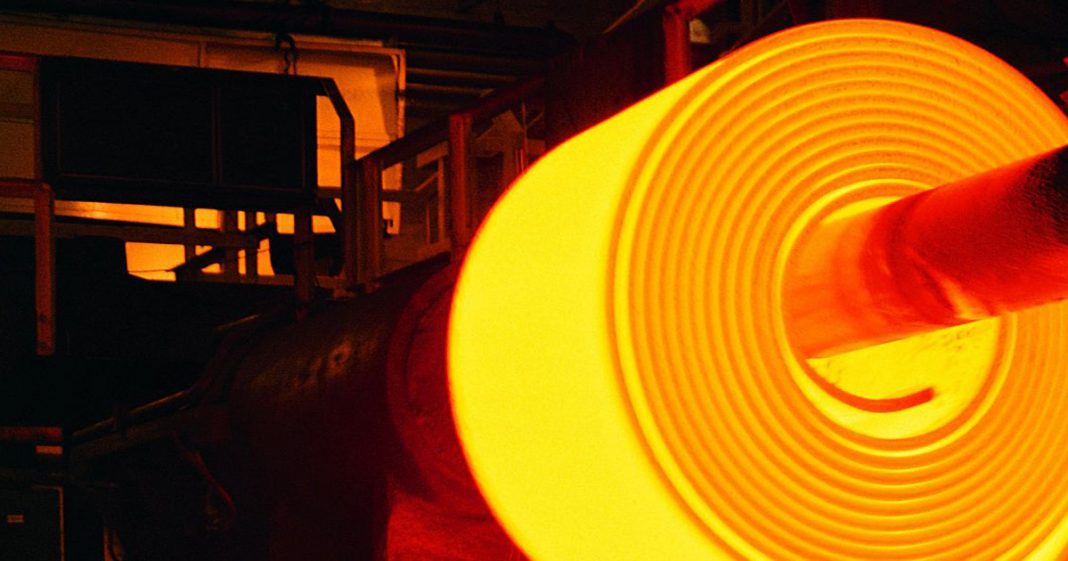 hot coil in a furnace being made. Illuminated steel coil in the dark