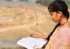 A girl reading a book with desert in background: education