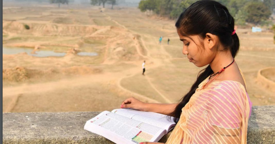 A girl reading a book with desert in background: education