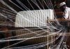 A man working on a loom( textile sector)