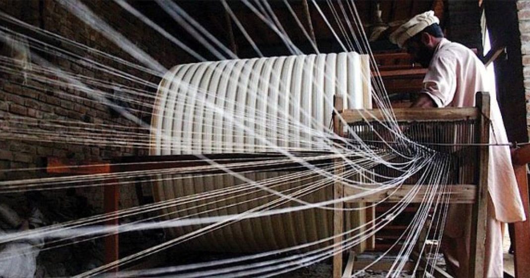 A man working on a loom( textile sector)