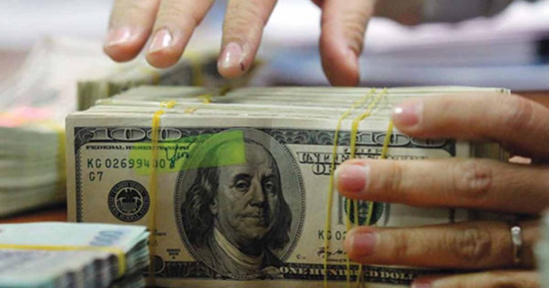 Shows a person with a stack of dollars