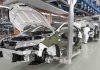 Shows automobile manufacturing unit with white cars being