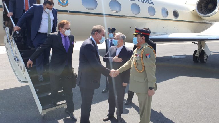FM Qureshi shaking hand on the tarmac with a military person